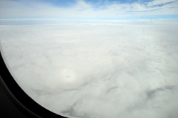 厚い雲に小さく機体の陰が